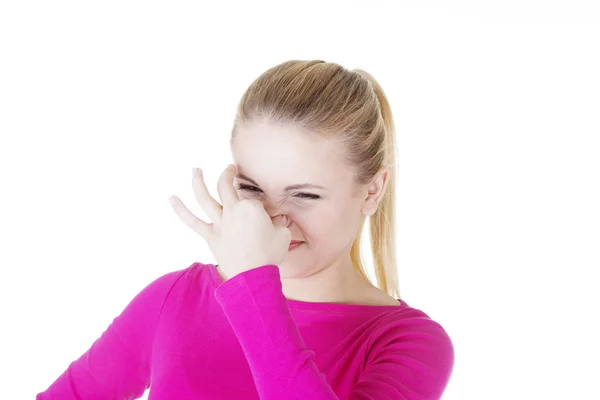 Mujer cubre la nariz con la mano mostrando que algo apesta — Foto de Stock