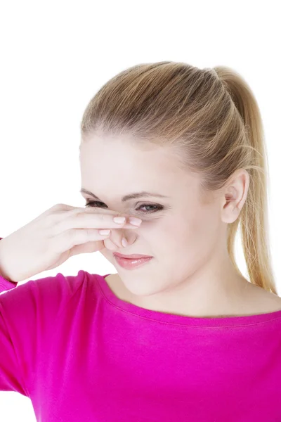 Frau bedeckt Nase mit Hand und zeigt, dass etwas stinkt — Stockfoto