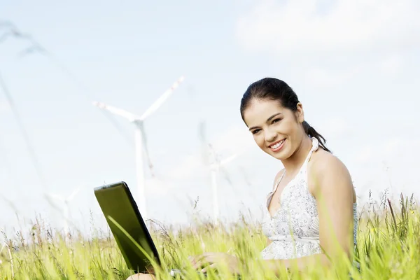 Teen flicka med laptop vid vindkraftverk. — Stockfoto