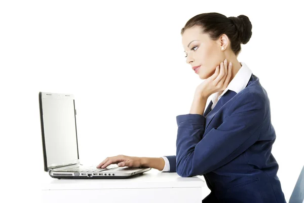 Mooie brunette zakenvrouw die op laptop werkt — Stockfoto