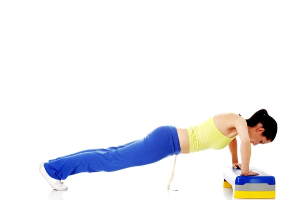 Fitness girl is working out with stepper. — Stock Photo, Image