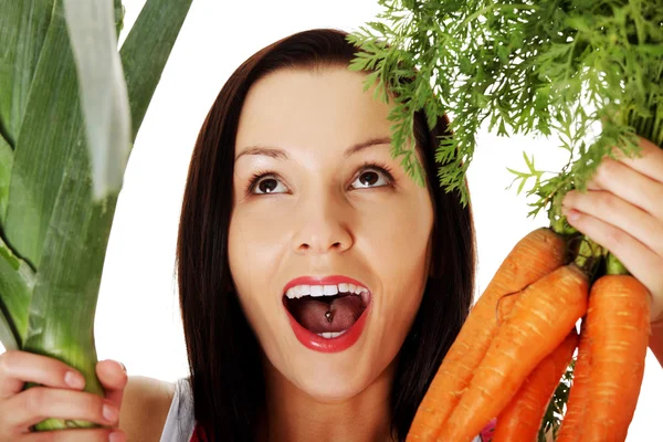 Happy woman in apron holding fresh leek and carrot — Stock Photo, Image