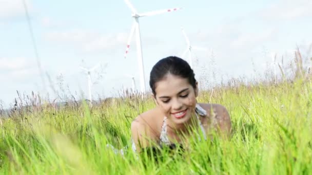 Chica adolescente con ordenador portátil al lado de la turbina eólica . — Vídeos de Stock