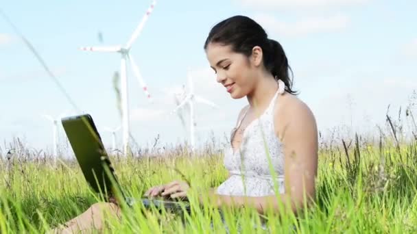 Teenager-Mädchen mit Laptop neben Windkraftanlage. — Stockvideo