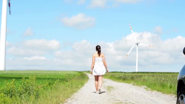 Gelukkig tiener meisje naast je eigen windturbine. — Stockvideo