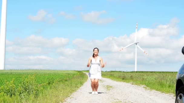 Gelukkig tiener meisje naast je eigen windturbine. — Stockvideo