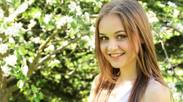 Hermosa mujer joven en el jardín floreciente — Vídeos de Stock