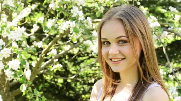 Hermosa mujer joven en el jardín floreciente — Vídeos de Stock