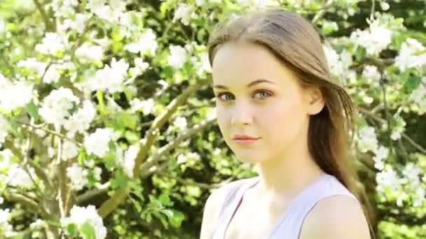Mooie jonge vrouw in de bloeiende tuin — Stockvideo