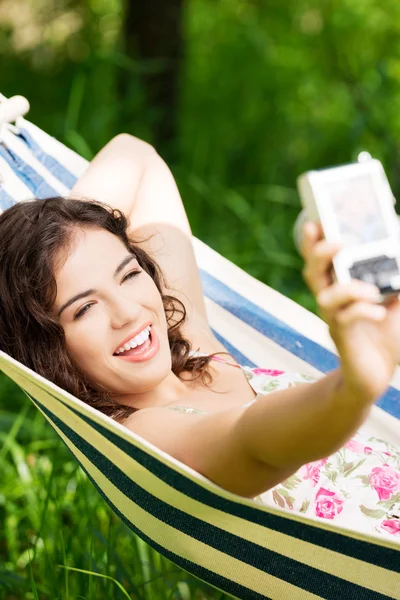 Young woman in a hammock in garden doing snapshot. — Stock Photo, Image