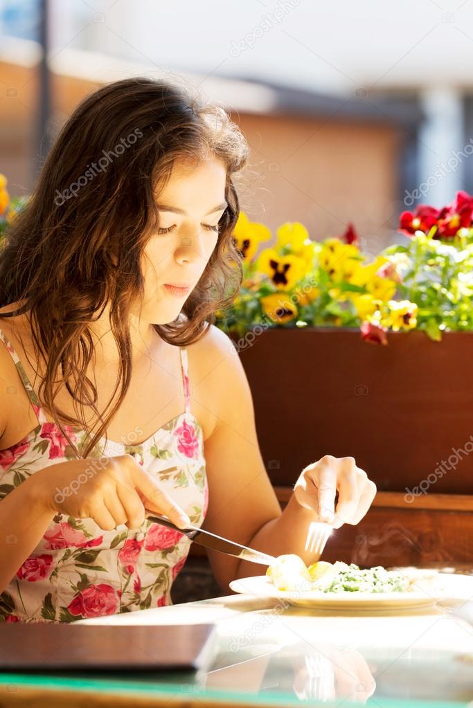 Young summer woman eating dinner.