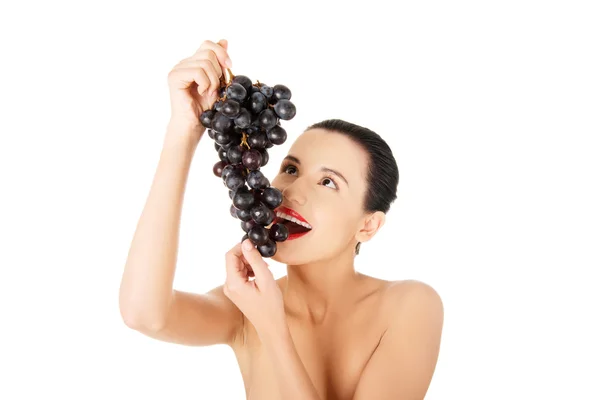 Smukke sensuelle brunette spiser druer - Stock-foto