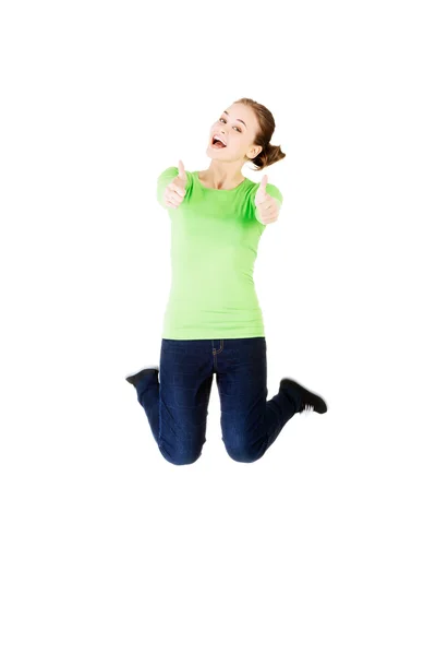 Young happy caucasian woman jumping in the air with thumbs up — Stock Photo, Image