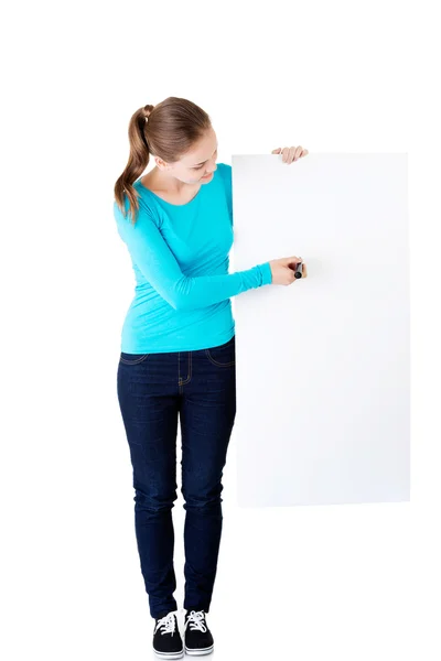 Happy beautiful woman writing with a pen on blank board. — Stock Photo, Image