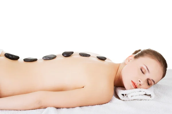 Mulher de beleza relaxante no spa. Massagem em pedra . — Fotografia de Stock