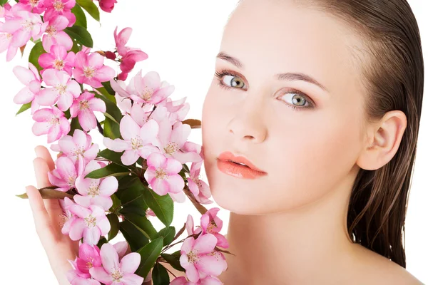 Krása tvář mladé krásné ženy s květinou. — Stock fotografie