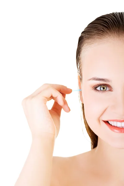 Mulher rosto close-up enquanto limpa uma orelha com um cotonete — Fotografia de Stock