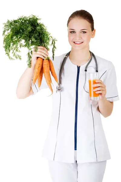 Female doctor holding healthy carrots. — Stock Photo, Image