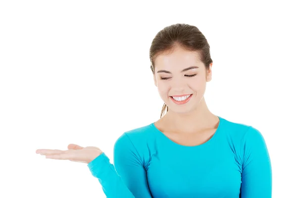 Happy , excited young woman presenting copy space on her palm — Stock Photo, Image