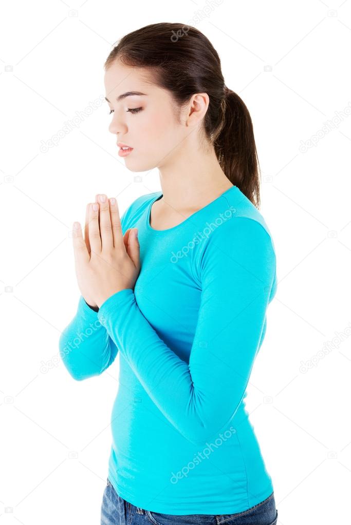 Young pretty caucasian girl praying
