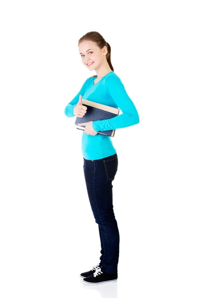 Attractive young student woman with book gesturing OK — Stock Photo, Image