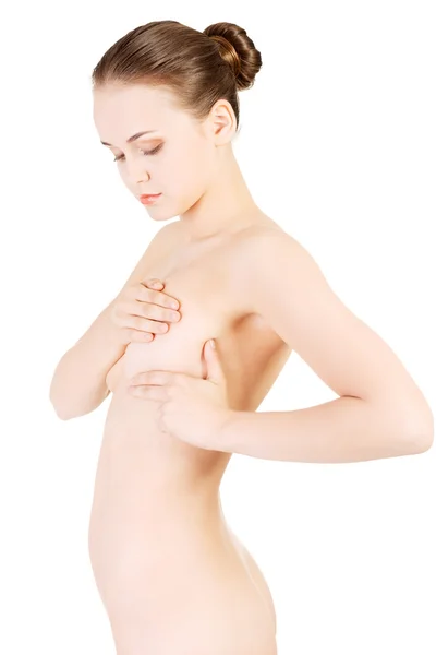 Женщина осматривает грудь на наличие опухолей или признаков рака груди — стоковое фото