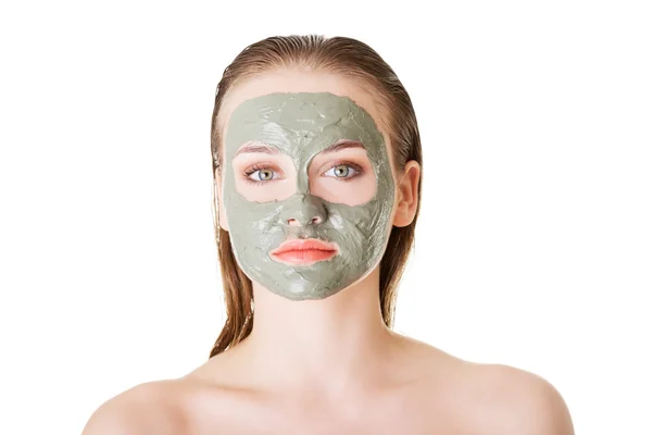 Beautiful woman with clay facial mask, isolated on white — Stock Photo, Image