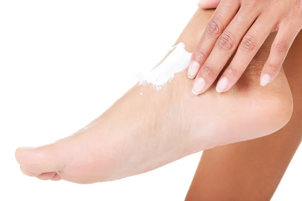 Mains féminines traitant les pieds avec de la crème hydratante — Photo