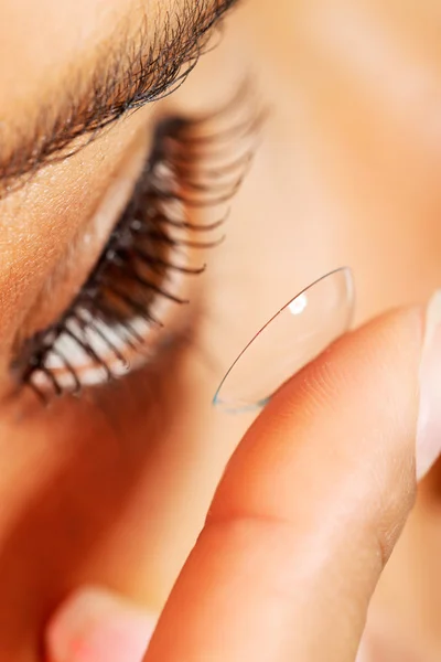Kvinnan sätter kontaktlins i ögat — Stockfoto