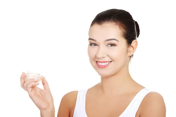 Woman applying lifting cream from container on face — Stock Photo, Image