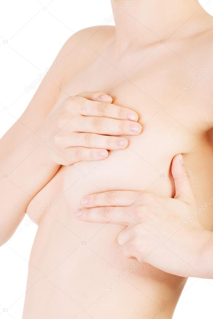 Woman examining her breast for lumps or signs of breast cancer