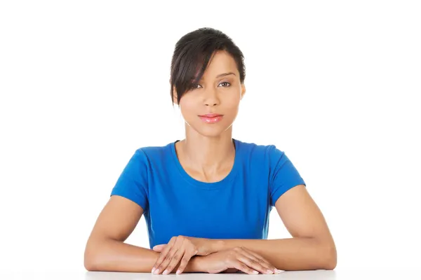 Bonita, feliz, joven mujer con ropa casual sentada en el escritorio — Foto de Stock