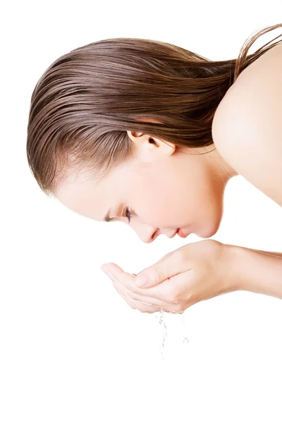 Young female washing her face with clear water Stock Photo