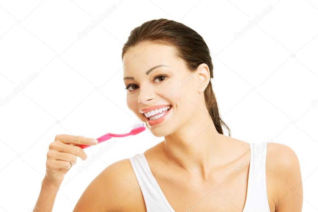 Young beautiful woman washing her teeth