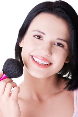 çekici bir kadın yüzüne makyaj yapıyor.