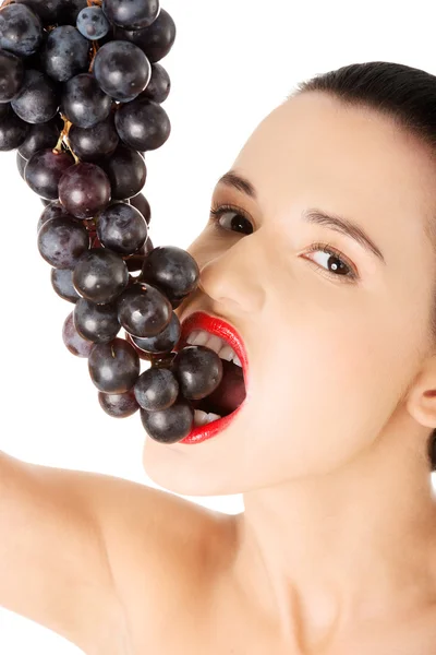 Beautiful sensual brunette eating grapes — Stock Photo, Image