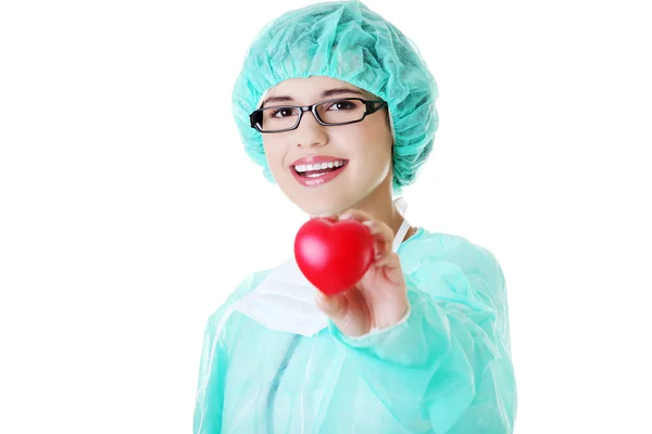 Médico o enfermera sonriente sosteniendo el corazón rojo —  Fotos de Stock