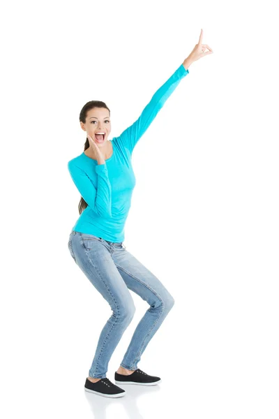 Excited young woman pointing on copy space — Stock Photo, Image