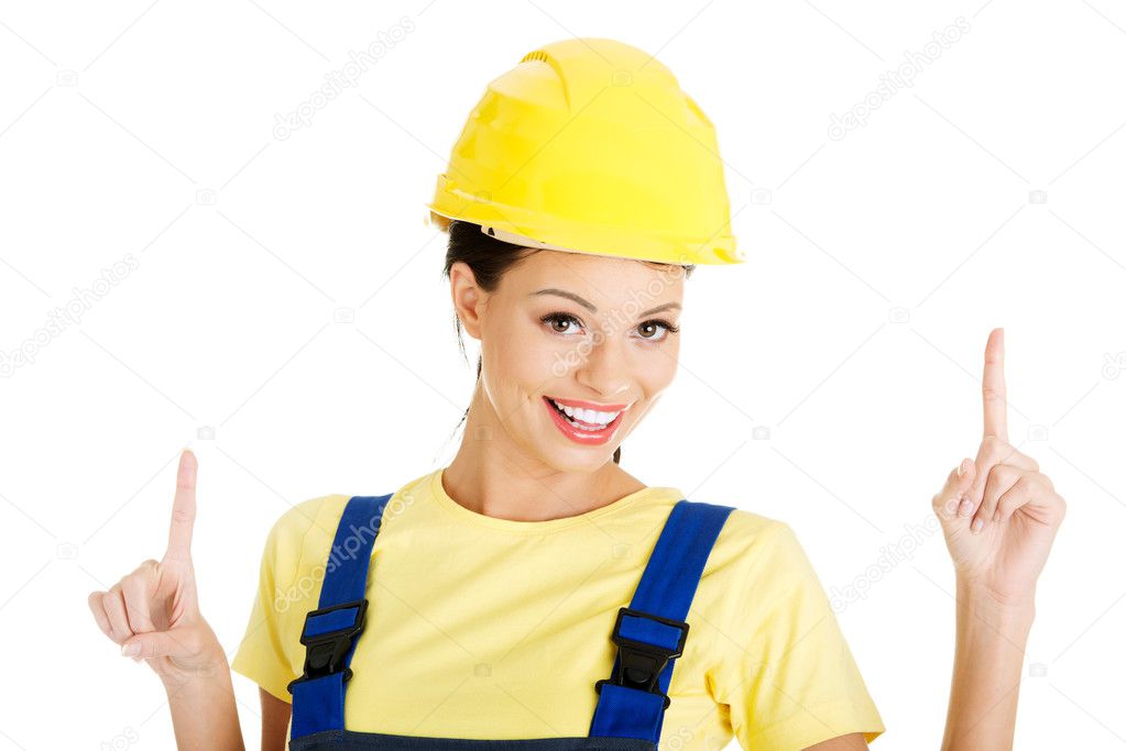 Female construction worker pointing on copy space