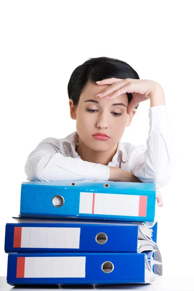 Triste femme avec des classeurs assis au bureau . — Photo