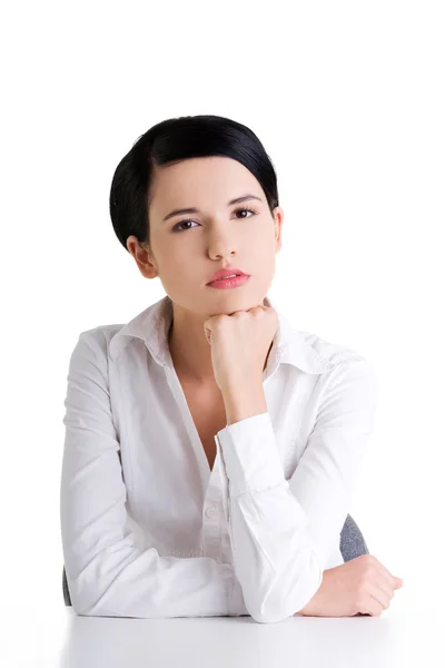 Jolie jeune femme assise au bureau — Photo