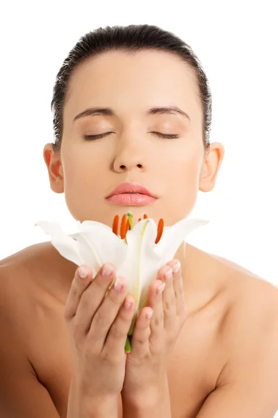 Mulher com pele saudável e com flor de lírio — Fotografia de Stock