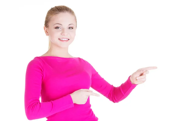 Blij, opgewonden jonge vrouw wijzend op kopie ruimte — Stockfoto