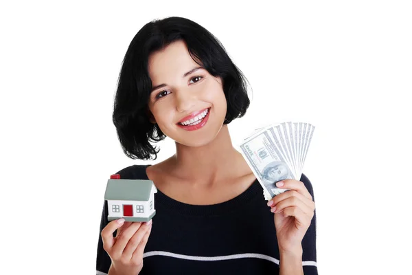 Mulher segurando notas de dólares americanos e modelo de casa — Fotografia de Stock