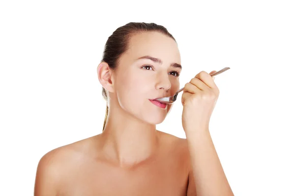 Teen girl with spoon in mouth. — Stock Photo, Image