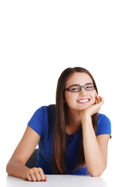 Estudante sorrindo menina sentada na mesa — Fotografia de Stock