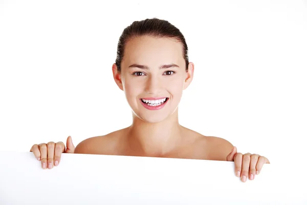 Beautiful teen girl behind big blank billboard — Stock Photo, Image