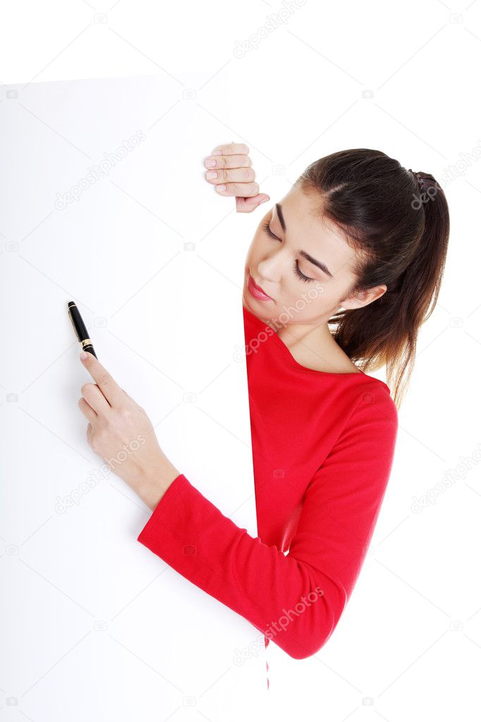 Happy woman writing with a pen on blank board.