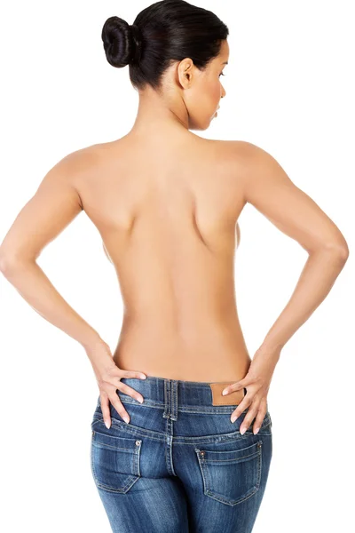 Beautiful and sexy woman standing in jeans topless. — Stock Photo, Image