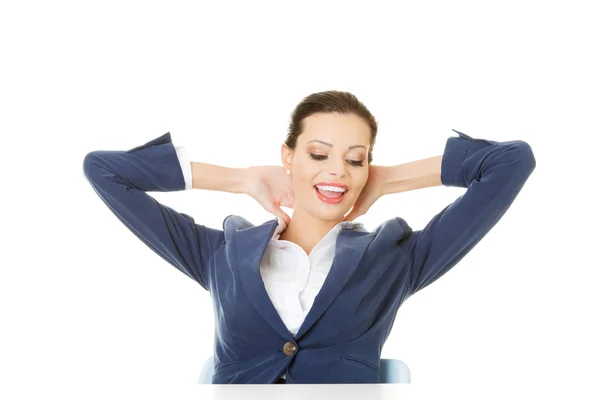 Attractive woman sitting with her hands behind her neck. — Stock Photo, Image